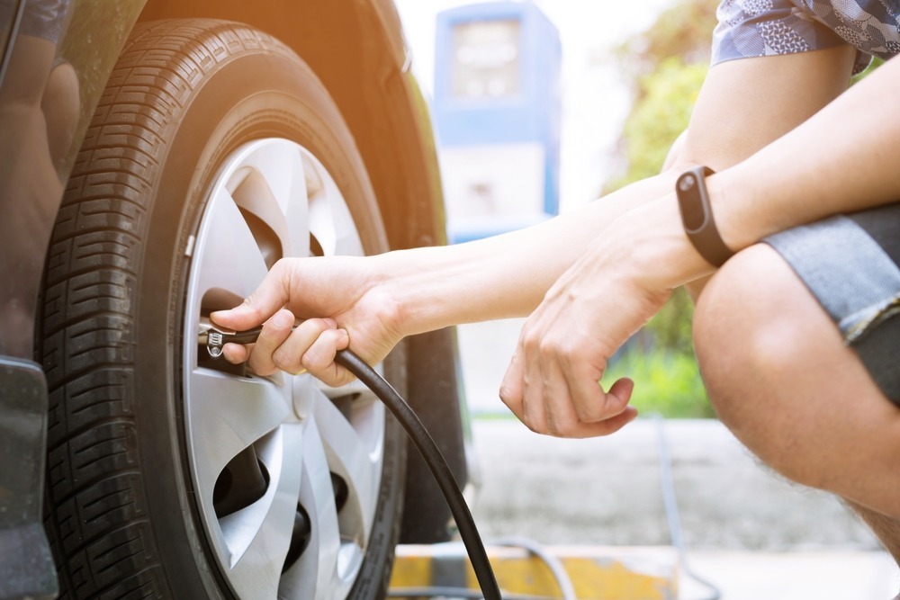 person filling a car tire with air person filling a car tire with air